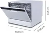 A white countertop dishwasher with its door open, showing the interior racks. Dimensions are indicated with lines and text. Produktbild-Vorschau