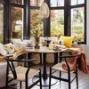 A dining set in a sunroom with large windows overlooking a garden. Podgląd zdjęcia produktu