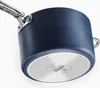 A close-up, angled view of the bottom and side of a dark blue saucepan. Anteprima dell’immagine prodotto