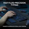 A person's hands typing on a Logitech keyboard in a dimly lit office setting. Produktbild-Vorschau