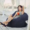 A woman is relaxing on a large bean bag chair outdoors, holding a drink. Náhľad obrázku produktu