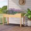 A wooden raised garden bed filled with purple and green plants sits on a wooden deck next to a white railing and house. Produktbild-Vorschau