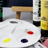 A close-up view of an artist's palette with paint tubes in the background. Podgląd zdjęcia produktu