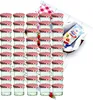 A large group of small glass jars with red and white checkered lids, arranged in rows. A small packet with text and images of fruit is visible in the background. Anteprima dell’immagine prodotto