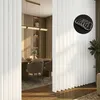 A room divider curtain is shown in a modern interior setting, with a dining area visible in the background. Voir les images du produit