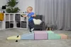 A toddler plays on a set of colorful foam climbing blocks indoors. Podgląd zdjęcia produktu