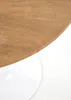 A close-up view of a round wooden table with a white base, set against a white background. Produktbild-Vorschau