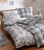A neatly made bed with a duvet and pillows, featuring a floral pattern on one side and a plaid pattern on the other. Produktbild-Vorschau