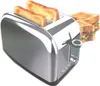 A chrome toaster with two slices of toast in it, and a sandwich in the background. Anteprima dell’immagine prodotto