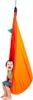 A young boy sits in a colorful hanging pod. Produktbild-Vorschau