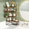 A corner shelf unit with various bathroom items displayed on it, next to a sink and a backlit mirror. Produktbild-Vorschau