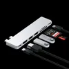 A silver USB hub and various accessories are arranged on a black background. Produktbild-Vorschau