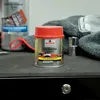 A can of NIGRIN Fein-Spachtel is placed on a dark surface next to a gray towel and a clear glass object. Anteprima dell’immagine prodotto