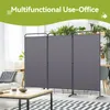 A gray, three-panel room divider is set up in a living room, separating a seating area from a dining area with plants in the background. Produktbild-Vorschau