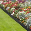A close-up view of a garden bed with a black metal edging separating it from a green lawn. Produktbild-Vorschau