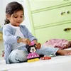 A young girl is playing with a LEGO DUPLO Minnie Mouse toy on the floor in front of a green dresser. Anteprima dell’immagine prodotto
