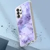A smartphone case with a marble pattern is shown at an angle, with debris falling around it. Produktbild-Vorschau