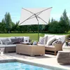 An outdoor patio scene with a sectional sofa, coffee table, and umbrella next to a swimming pool. Produktbild-Vorschau