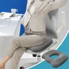 A person is sitting on an office chair with a cushion on it, stretching their arms. Náhled obrázku produktu