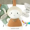 Close-up of a baby toy, a plush sheep with a rattle attached. Produktbild-Vorschau