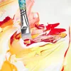 A close-up shot of a paintbrush mixing red and yellow paint on a white surface. Produktbild-Vorschau