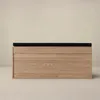 A wooden shoe cabinet with a black upholstered seat on top, set against a plain light beige background. Produktbild-Vorschau