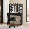 A black vanity table with a lighted mirror and stool, set up in a room with curtains and a window. Produktbild-Vorschau