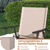 A close-up view of a beige outdoor chair with a black frame, set against a backdrop of green bushes and a wooden fence. Produktbild-Vorschau