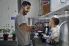 A man and a baby in a kitchen. Produktbild-Vorschau