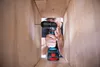 A person is using a cordless drill inside a wooden box. Voir les images du produit
