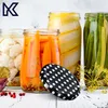 A collection of jars filled with pickled vegetables, including cauliflower, carrots, and green beans, with a polka-dot lid in the foreground. Produktbild-Vorschau