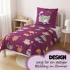 A child's bed with a purple duvet cover and pillow featuring a cartoon cat print. Produktbild-Vorschau