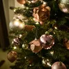 A close-up view of a decorated Christmas tree with various ornaments and lights. Náhled obrázku produktu