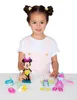 A young girl is sitting at a table with a Minnie Mouse doll and accessories. Produktbild-Vorschau