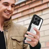 A man is holding a phone case in front of a brick wall. Anteprima dell’immagine prodotto