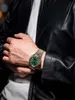 A person wearing a black leather jacket and a white t-shirt, showing off a watch on their wrist. Voir les images du produit