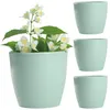 A set of four light green ceramic plant pots, with one pot in the foreground filled with white jasmine flowers and green leaves. Produktbild-Vorschau