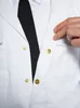 A close-up of a person wearing a white uniform jacket with a black tie, showing the snap buttons. Produktbild-Vorschau