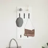 A white wall-mounted shelf with hooks, holding a cap and a bag. A tote bag is also visible in the foreground. Náhled obrázku produktu