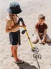 Two children are playing with a metal detector on a sandy beach. Náhľad obrázku produktu