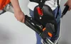 A person wearing a harness and holding a string trimmer. Produktbild-Vorschau