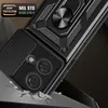 A close-up, angled shot of a black phone case with a ring stand and camera cover, shown as if falling and cracking the surface it's about to hit. Produktbild-Vorschau