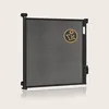 A black retractable baby gate is shown against a light beige background. Náhled obrázku produktu