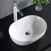 A white oval vessel sink with a modern white and chrome faucet on a black countertop. Anteprima dell’immagine prodotto