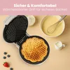 A waffle maker is shown open with a freshly baked heart-shaped waffle inside, surrounded by ingredients and a small pitcher of cream. Produktbild-Vorschau