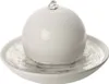 A white spherical fountain sits in a white bowl filled with water. Náhled obrázku produktu