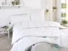 A neatly made bed with white bedding, pillows, and a duvet. Produktbild-Vorschau