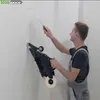 A man is using a drywall taping tool on a white wall. Náhľad obrázku produktu