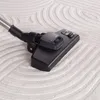 A close-up shot of a vacuum cleaner head on a textured carpet. Anteprima dell’immagine prodotto