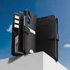 A black wallet-style phone case is displayed on a white surface against a blue sky background. Produktbild-Vorschau